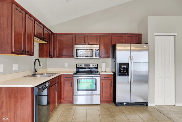 13225 Deception Pass Unit 700, Fishers, IN 46038 - kitchen featuring appliances with stainless steel finishes, vaulted ceiling, light countertops, light tile patterned floors, and reddish brown cabinets