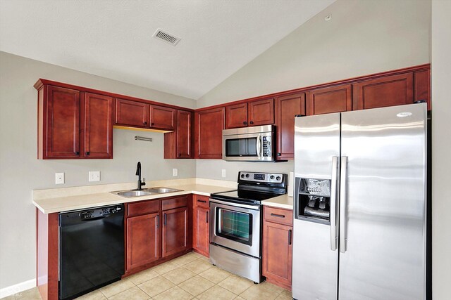 13225 Deception Pass Unit 700, Fishers, IN 46038 - kitchen with stainless steel appliances, reddish brown cabinets, lofted ceiling, light countertops, and light tile patterned floors