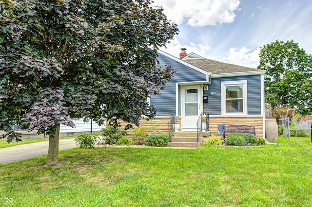 1810 Calhoun St, Indianapolis, IN 46203 - view of front of house with entry steps, a front yard, a chimney, stone siding, and a shingled roof
