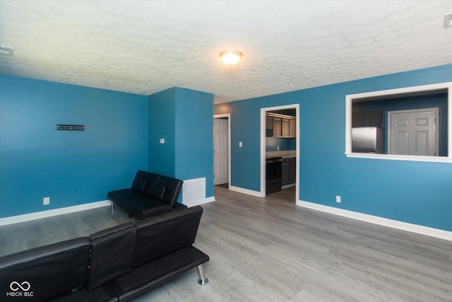 8047 E 48th St, Indianapolis, IN 46226 - unfurnished living room featuring a textured ceiling and wood finished floors