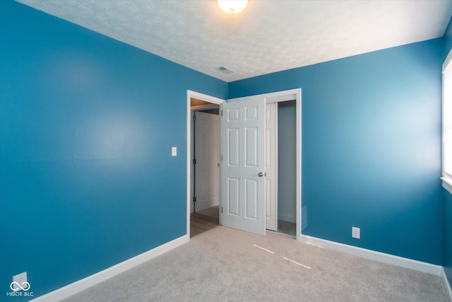 8047 E 48th St, Indianapolis, IN 46226 - unfurnished bedroom featuring a closet, a textured ceiling, and carpet flooring