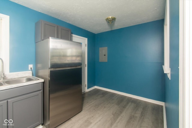 8047 E 48th St, Indianapolis, IN 46226 - kitchen featuring freestanding refrigerator, gray cabinetry, wood finished floors, electric panel, and a textured ceiling