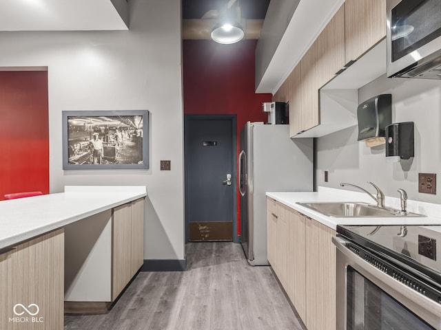 430 N Park Ave Unit 104, Indianapolis, IN 46202 - kitchen featuring stainless steel appliances, light countertops, and light wood-type flooring