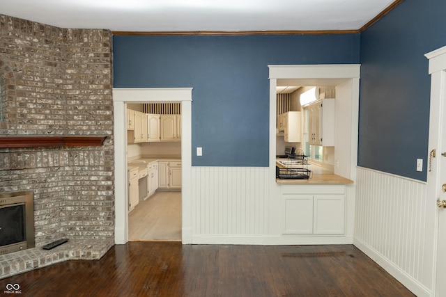 602 Valley Dr, Crawfordsville, IN 47933 - unfurnished living room featuring a wainscoted wall, wood finished floors, a fireplace, and crown molding