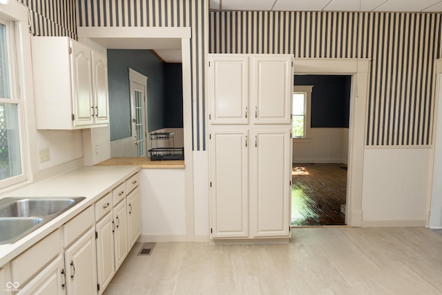 602 Valley Dr, Crawfordsville, IN 47933 - kitchen with light wood-type flooring, light countertops, and white cabinetry