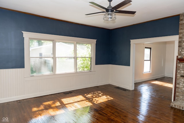 602 Valley Dr, Crawfordsville, IN 47933 - spare room featuring wainscoting, ceiling fan, hardwood / wood-style floors, and a brick fireplace