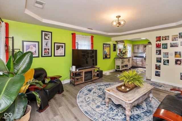 921 Morgan Dr, Indianapolis, IN 46227 - living area featuring arched walkways, a tray ceiling, wood finished floors, and a chandelier