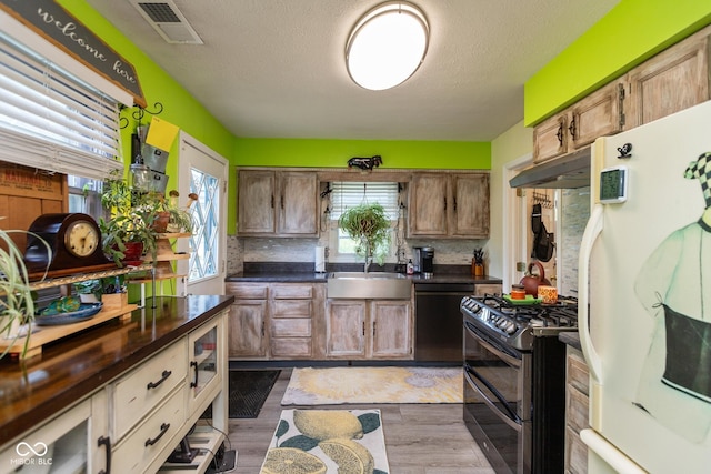 921 Morgan Dr, Indianapolis, IN 46227 - kitchen with freestanding refrigerator, double oven range, dishwashing machine, under cabinet range hood, and dark countertops