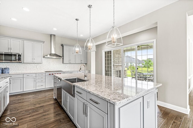 14293 Dufton Ct, Carmel, IN 46074 - kitchen with wall chimney range hood, stainless steel microwave, a kitchen island with sink, dark wood finished floors, and tasteful backsplash