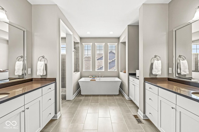 14293 Dufton Ct, Carmel, IN 46074 - bathroom featuring a soaking tub, a tile shower, two vanities, and recessed lighting