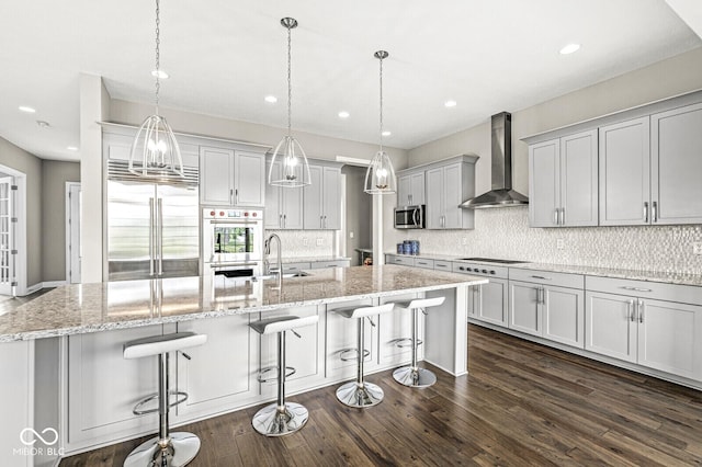 14293 Dufton Ct, Carmel, IN 46074 - kitchen featuring wall chimney exhaust hood, stainless steel appliances, backsplash, a large island, and dark wood-style floors