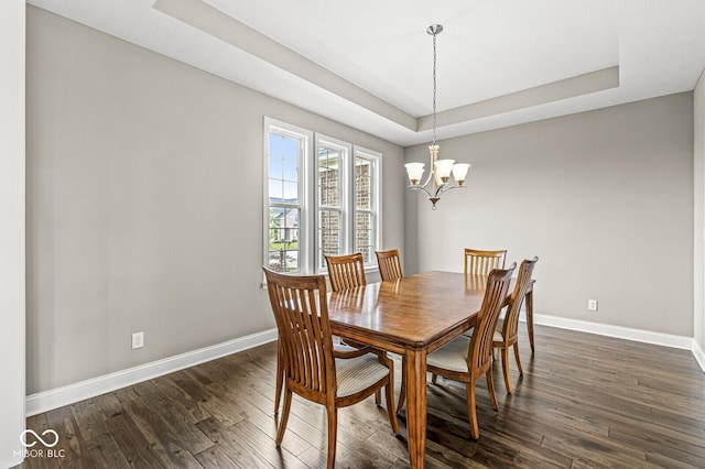 14293 Dufton Ct, Carmel, IN 46074 - dining area featuring a tray ceiling, dark wood finished floors, and a chandelier