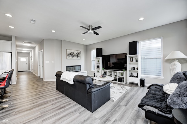 8108 Nik St, Brownsburg, IN 46112 - living area featuring light wood-style flooring, a ceiling fan, recessed lighting, and a glass covered fireplace