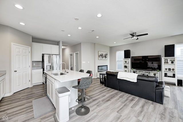 8108 Nik St, Brownsburg, IN 46112 - kitchen with light wood-style flooring, open floor plan, white cabinetry, recessed lighting, and light countertops
