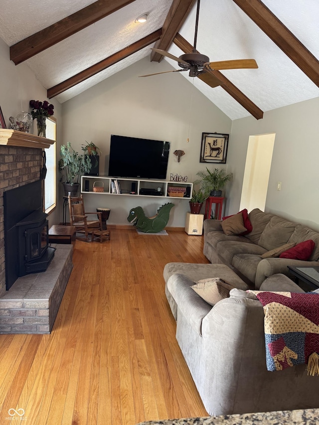 1220 Countryside Ln, Columbus, IN 47201 - living room featuring a wood stove, beamed ceiling, wood finished floors, a ceiling fan, and high vaulted ceiling