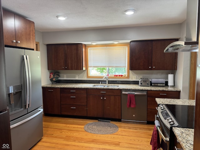 1220 Countryside Ln, Columbus, IN 47201 - kitchen with appliances with stainless steel finishes, wall chimney exhaust hood, light wood-style floors, dark brown cabinetry, and light stone countertops
