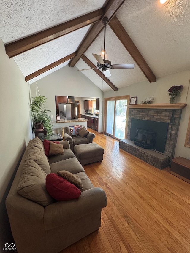 1220 Countryside Ln, Columbus, IN 47201 - living area featuring a textured ceiling, light wood-style flooring, ceiling fan, and a fireplace
