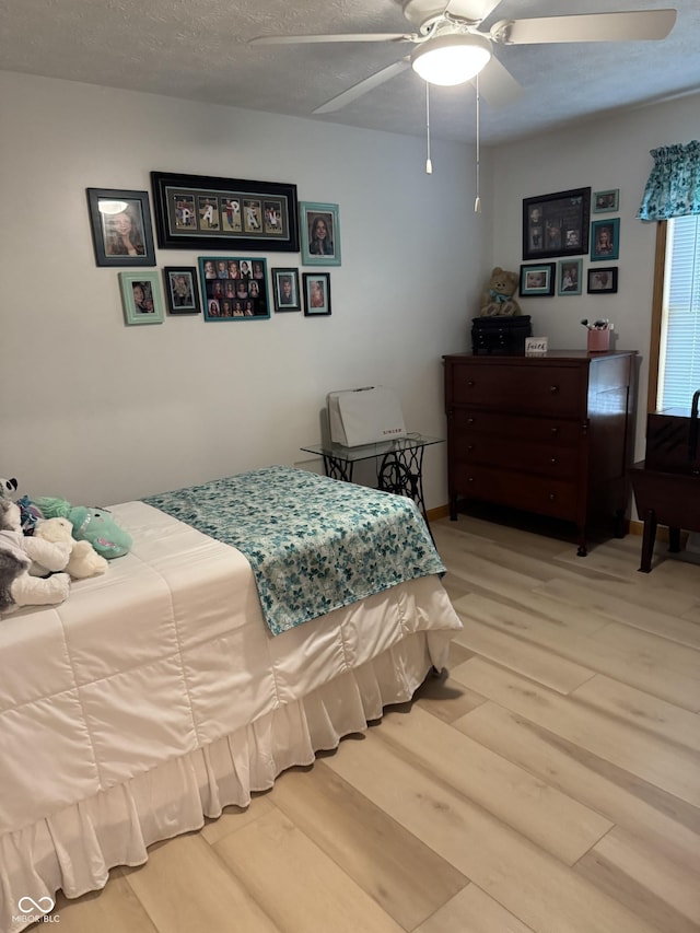 1220 Countryside Ln, Columbus, IN 47201 - bedroom featuring light wood finished floors, ceiling fan, and a textured ceiling