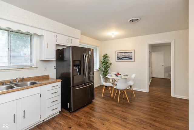 5702 E 17th St, Indianapolis, IN 46218 - kitchen with stainless steel fridge, dark wood finished floors, white cabinets, and plenty of natural light