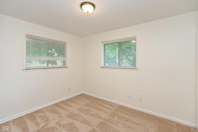 5702 E 17th St, Indianapolis, IN 46218 - spare room featuring light colored carpet and healthy amount of natural light