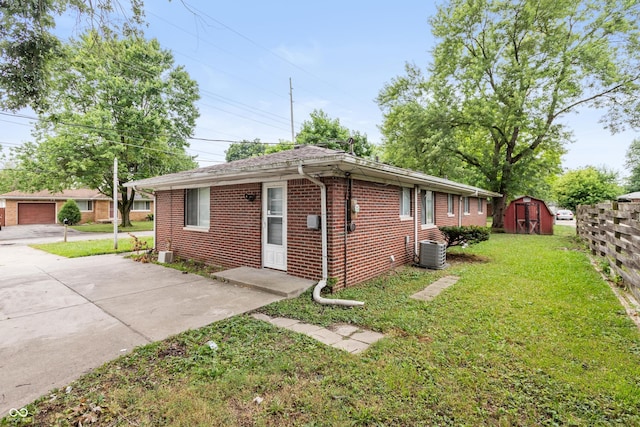 5702 E 17th St, Indianapolis, IN 46218 - view of home's exterior featuring brick siding, a lawn, and a shed