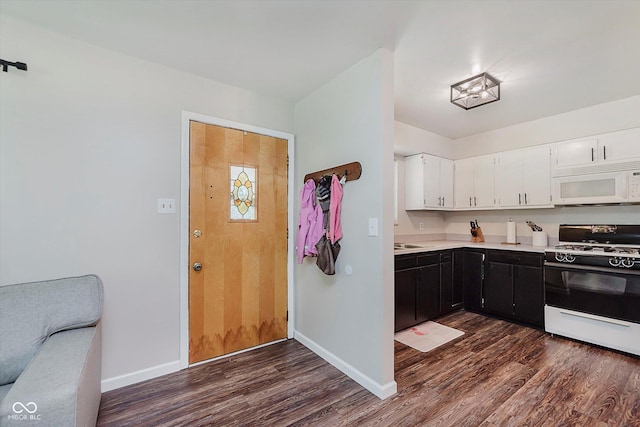 47 Habig Rd, Indianapolis, IN 46217 - kitchen with white microwave, range with gas stovetop, dark wood finished floors, dark cabinets, and light countertops