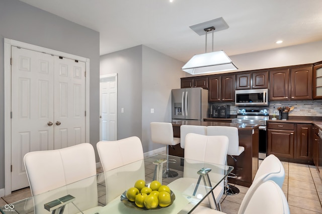 2847 Macintosh, Columbus, IN 47201 - kitchen featuring stainless steel appliances, light tile patterned floors, tasteful backsplash, hanging light fixtures, and dark brown cabinetry
