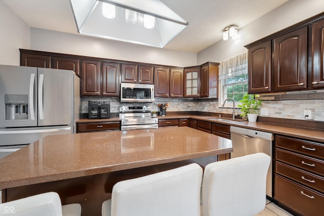 2847 Macintosh, Columbus, IN 47201 - kitchen with appliances with stainless steel finishes, a breakfast bar, dark brown cabinetry, and backsplash