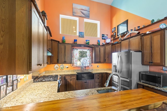7437 Center Lake Rd, Nineveh, IN 46164 - kitchen with stainless steel appliances, light stone countertops, a towering ceiling, and under cabinet range hood