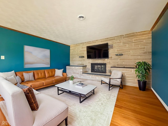 8883 W Hilltop Ln, Elwood, IN 46036 - living room featuring wood finished floors, an accent wall, and a fireplace