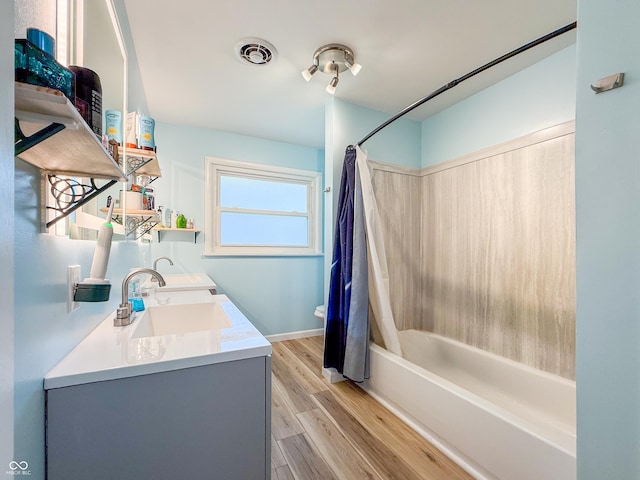 8883 W Hilltop Ln, Elwood, IN 46036 - bathroom featuring shower / bathtub combination with curtain, double vanity, and wood finished floors
