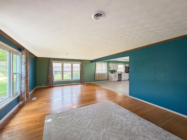 8883 W Hilltop Ln, Elwood, IN 46036 - unfurnished living room featuring baseboards and light wood-type flooring