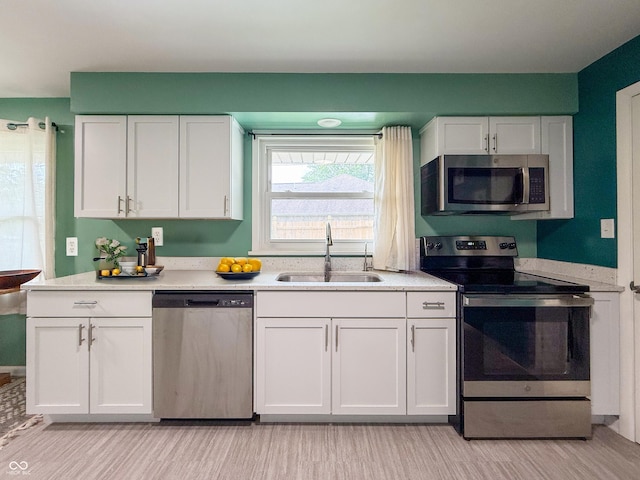 8883 W Hilltop Ln, Elwood, IN 46036 - kitchen featuring stainless steel appliances, white cabinets, light countertops, and light wood-style floors