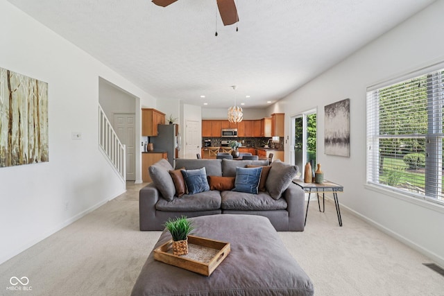 10792 Sawgrass Dr, Fishers, IN 46037 - living area with light carpet, a ceiling fan, stairs, a textured ceiling, and recessed lighting
