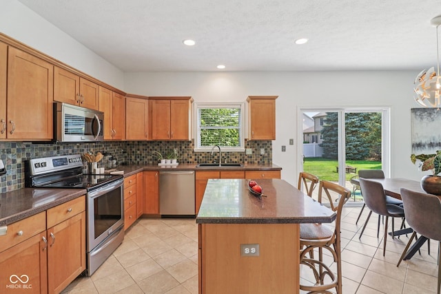 10792 Sawgrass Dr, Fishers, IN 46037 - kitchen with stainless steel appliances, a breakfast bar, backsplash, light tile patterned floors, and recessed lighting