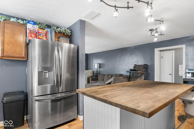 43 W Main St, North Vernon, IN 47265 - kitchen with stainless steel refrigerator with ice dispenser, butcher block countertops, light wood finished floors, a textured ceiling, and a center island