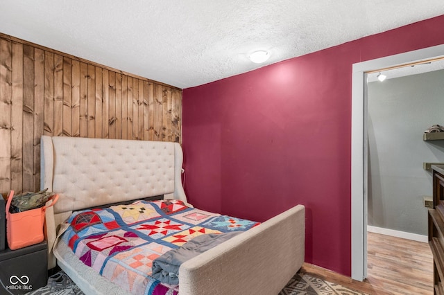 43 W Main St, North Vernon, IN 47265 - bedroom with a textured ceiling, wood finished floors, and wood walls