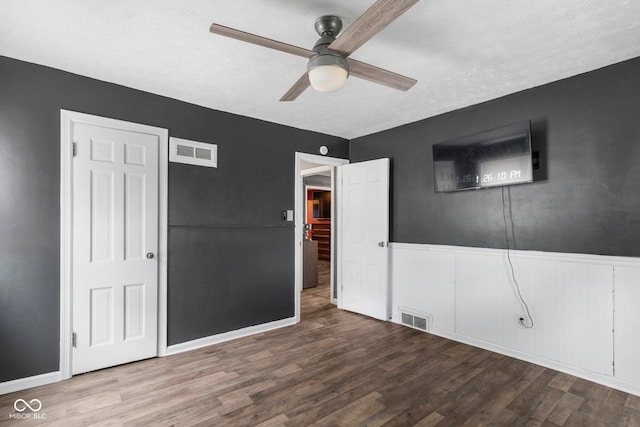 43 W Main St, North Vernon, IN 47265 - unfurnished bedroom featuring wood finished floors, wainscoting, and a ceiling fan