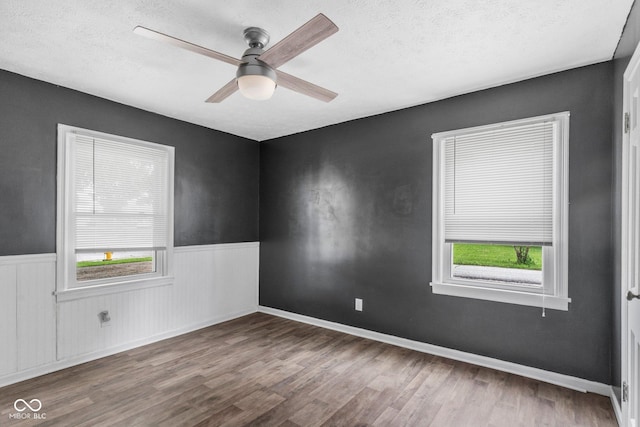 43 W Main St, North Vernon, IN 47265 - unfurnished room with plenty of natural light, wood finished floors, wainscoting, a textured ceiling, and a ceiling fan