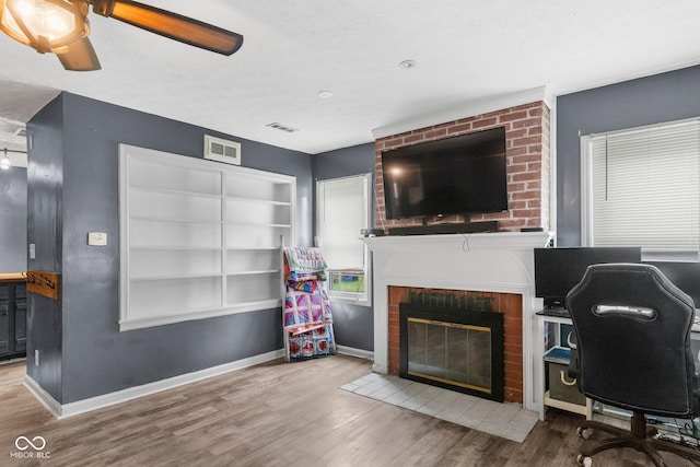 43 W Main St, North Vernon, IN 47265 - home office featuring wood finished floors, a ceiling fan, and a brick fireplace