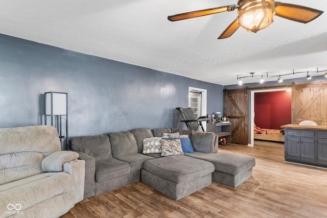 43 W Main St, North Vernon, IN 47265 - living room featuring a barn door, light wood-style floors, and a ceiling fan