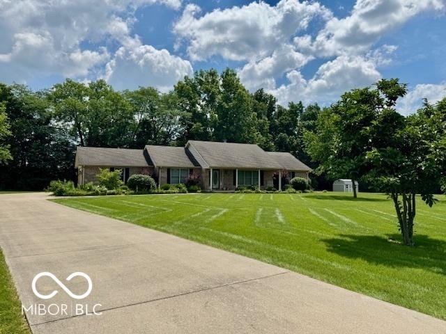 1042 W Oak Hill Xing, Crawfordsville, IN 47933 - ranch-style home featuring a front lawn, a shed, and view of scattered trees