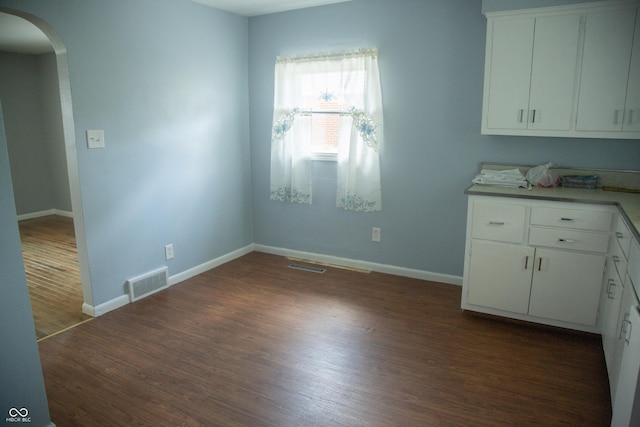 12 E N St, New Palestine, IN 46163 - unfurnished dining area with arched walkways and dark wood-style flooring
