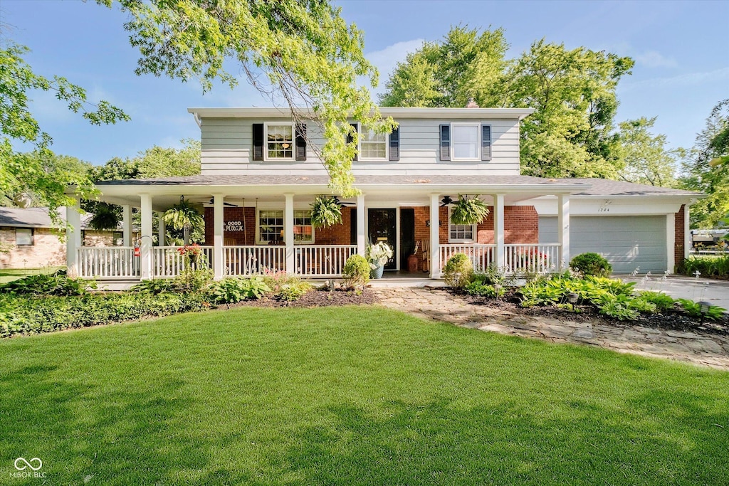 1244 Darby Ln, Indianapolis, IN 46260 - farmhouse with a porch, brick siding, a front lawn, and a garage