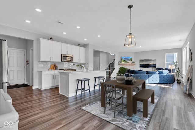 9978 Trafford Ct, Mccordsville, IN 46055 - dining space with recessed lighting, wood finished floors, and stairway