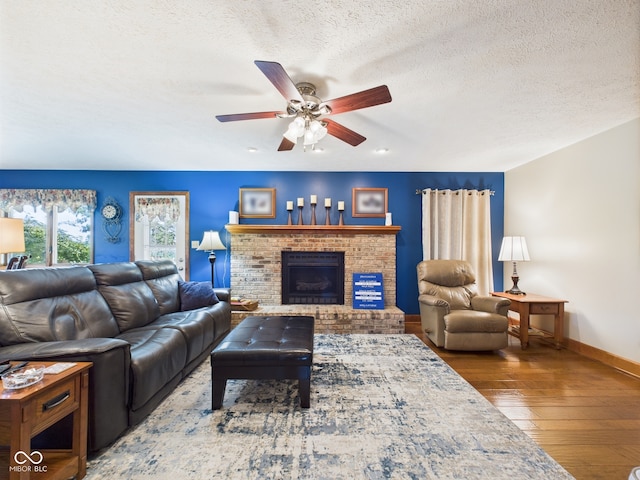 1014 Gray Squirrel Dr, Pendleton, IN 46064 - living area with a ceiling fan, hardwood / wood-style flooring, a brick fireplace, and a textured ceiling