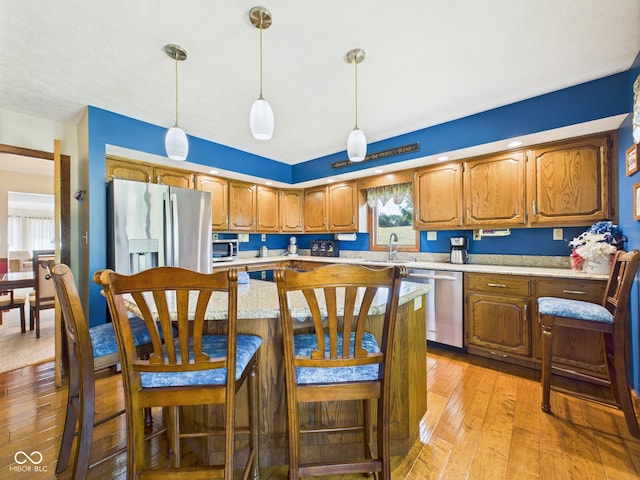 1014 Gray Squirrel Dr, Pendleton, IN 46064 - kitchen featuring stainless steel appliances, light countertops, light wood-style flooring, and brown cabinets