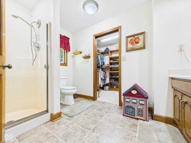 1014 Gray Squirrel Dr, Pendleton, IN 46064 - bathroom featuring vanity, a stall shower, a walk in closet, tile patterned floors, and a textured ceiling