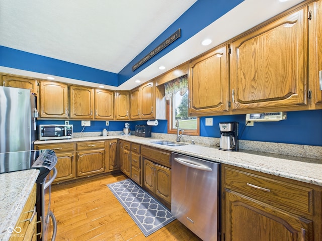 1014 Gray Squirrel Dr, Pendleton, IN 46064 - kitchen featuring appliances with stainless steel finishes, light wood-type flooring, brown cabinetry, light stone counters, and recessed lighting