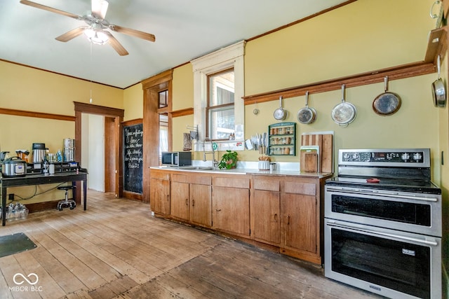 9665 N County Rd 250 E, Frankfort, IN 46041 - kitchen with stainless steel appliances, light wood-style flooring, light countertops, ceiling fan, and ornamental molding